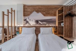 塞斯特雷HOTIDAY Chalet Sestriere Vialattea的配有山壁画的客房内的两张床