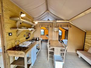 莱科Glamping Camping Rivabella的一间小房子的厨房和用餐区