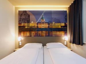 柏林B&B Hotel Berlin City-West的两张位于酒店客房的床,墙上挂着照片