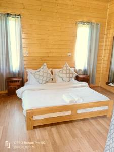 古尔马尔格The Frozenfall Resort的卧室配有一张带白色床单和枕头的大床。