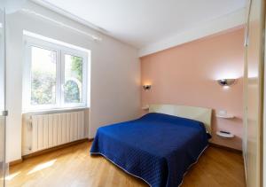 圣托斯特凡诺港Casa del Sole的一间卧室设有蓝色的床和窗户。