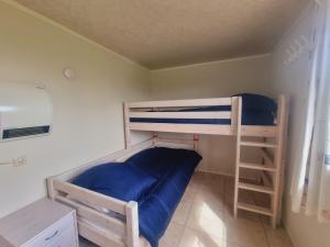 布兰肯贝赫Beachside Vakantiepark的一间卧室配有两张双层床,铺有蓝色床单。