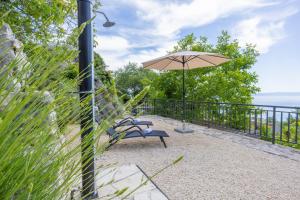 马卡尔斯卡Holiday home Tranquillo的一个带椅子和遮阳伞的庭院