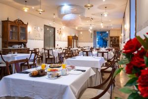 圣米良德拉科戈利亚圣米良莫纳斯特瑞酒店的餐厅配有白色的桌椅,提供食物