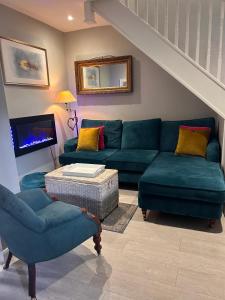 基督城Boutique Townhouse in Christchurch Dorset的客厅配有蓝色的沙发和椅子