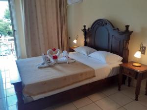阿吉亚玛丽娜加里尼酒店的一间卧室配有一张带两个天鹅的床