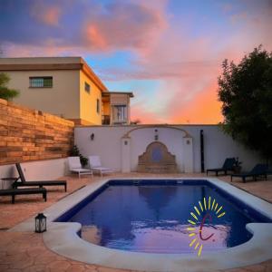 圣玛丽亚港casa de vicky的庭院中的游泳池,背景是日落