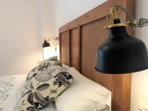 隆达隆达中心恩艾尔公寓的一张带黑灯和枕头的床