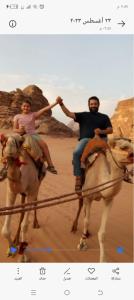 DisahOmar Camp Wadi Rum的男人和女人在沙漠里骑马