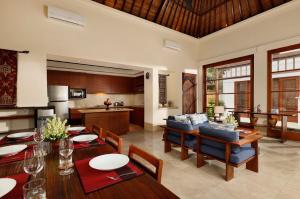 金巴兰Jimbaran Beach Villas by Nakula的厨房以及带桌椅的起居室。