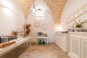 法萨诺Masseria San Nicola Savelletri - B&B的一间大厨房,配有白色的橱柜和柜台