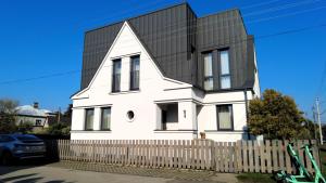 考纳斯Žalio kalno apartamentai的黑色屋顶的白色房子