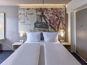 波恩B&B Hotel Bonn-City的卧室配有一张带两个枕头的大白色床