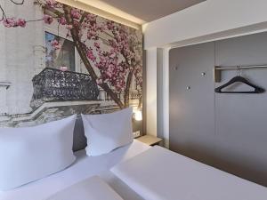 波恩B&B Hotel Bonn-City的卧室配有一张白色床,墙上挂有绘画作品