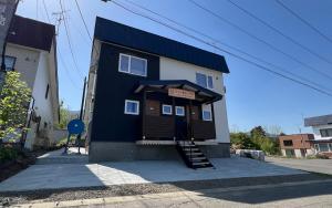 富良野Furano Yukisachi House的蓝色和白色的建筑,上面有标志