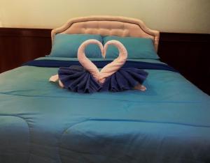 哈林海滩坦雅伯尔恩旅馆的两个粉红色的天鹅坐在床上
