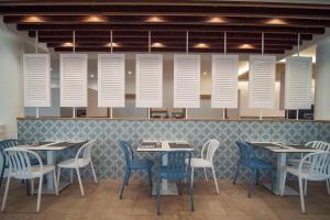 滨海托萨唐璜托萨酒店的一间配备有桌椅和白色通风口的餐厅