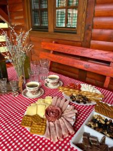 利夫诺Ranč Crna stina的一张桌子,上面有奶酪和其他食物,放在红色和白色的桌布上