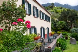 圣维森特卡萨达皮耶达德酒店的一座在院子里有粉红色花卉和长凳的建筑