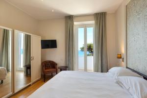 阿拉西奥美帝特拉奈大酒店的卧室设有一张白色大床和一扇窗户。