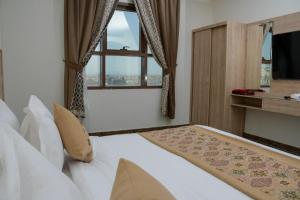 Qabāʼفندق ريست ان的一间卧室设有一张大床和一个窗户。