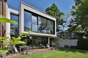格尔斯托芬Moderne Studio-Wohnung的一座带大型玻璃窗和庭院的房子