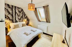 扎科帕内Luxury Houses & Apartments Zaliński的一间卧室配有一张床,上面有两条毛巾