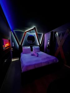 讷伊-普莱桑斯L'1TIMISTE的紫色灯光客房内的一张床位