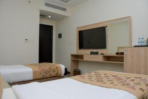 Qabāʼفندق ريست ان的酒店客房设有两张床和一台平面电视。