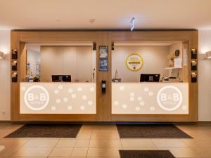 不来梅港B&B Hotel Bremerhaven的商店前方设有两个带柜台的玻璃门