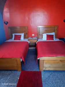 阿斯旺B&B Saluga Sehel Island Nubian House的红色墙壁客房的两张床