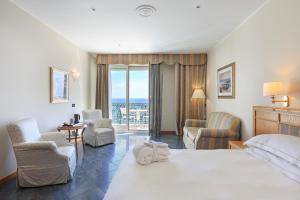 阿拉西奥美帝特拉奈大酒店的酒店客房带大型白色床和椅子