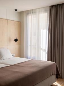 巴黎New Hotel Opéra的一间卧室设有一张床和一个大窗户