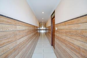 班加罗尔FabHotel BNS Comforts的走廊设有木板墙,走廊设有长长的走廊