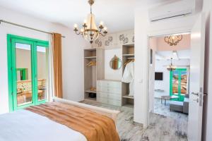 卡尔帕索斯La Scala Luxury Villa Μikis Theodorakis with jacuzzi的一间卧室配有一张床和一个吊灯