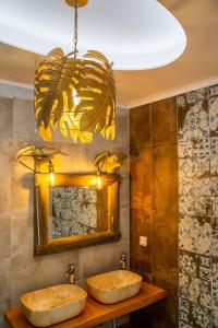 卡尔帕索斯La Scala Luxury Villa Μikis Theodorakis with jacuzzi的带吊灯的浴室内的2个水槽