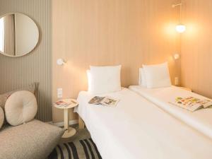 波尔多诺沃特波尔多拉克酒店的一间设有两张床、椅子和镜子的房间
