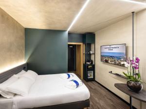热那亚诺富特热那亚欧维斯特酒店的一间卧室配有一张床和一台平面电视
