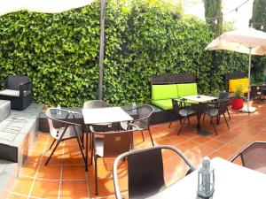 富恩拉夫拉达宜必思马德里丰拉夫拉达酒店的一个带桌椅的庭院和绿色树 ⁇ 