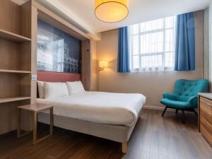利物浦利物浦市中心阿德吉奥公寓式酒店的酒店客房,配有一张床和一张蓝色椅子