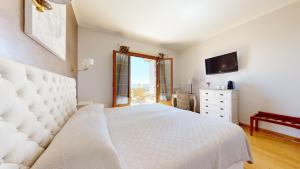 图尔图珀蒂特旅馆的卧室配有白色的床和电视。