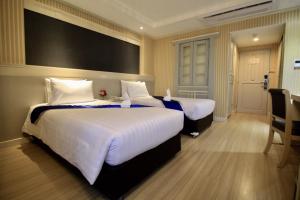 坤敬โรงแรมวีวิช V Wish Hotel的酒店客房,配有两张带白色床单的床
