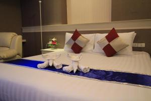 坤敬โรงแรมวีวิช V Wish Hotel的配有枕头的床的酒店客房