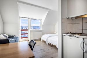 伊卢利萨特HOTEL SØMA Ilulissat的一间卧室配有一张床,厨房配有桌子