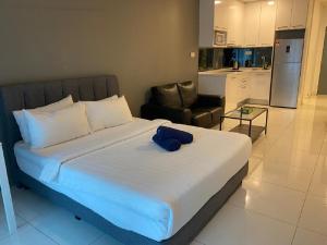 吉隆坡Mercu Summer Suite by Great Service的一间卧室配有一张带蓝色毛巾的床
