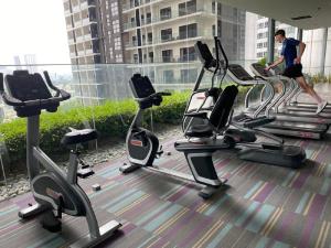 吉隆坡Mercu Summer Suite by Great Service的一个人在带有氧器材的健身房里行走