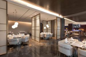 台州台州开投温德姆酒店的用餐室配有白色的桌子和白色的椅子