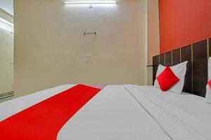 德里OYO Flagship Hotel Elite Inn的一间卧室配有红色和白色枕头的床