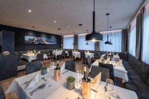 布列瑟农蒂罗尔酒店的餐厅设有白色的桌椅和窗户。