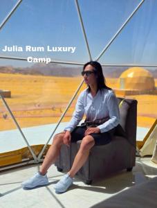 瓦迪拉姆Julia Rum Luxury Camp的双腿交叉坐在椅子上的女人